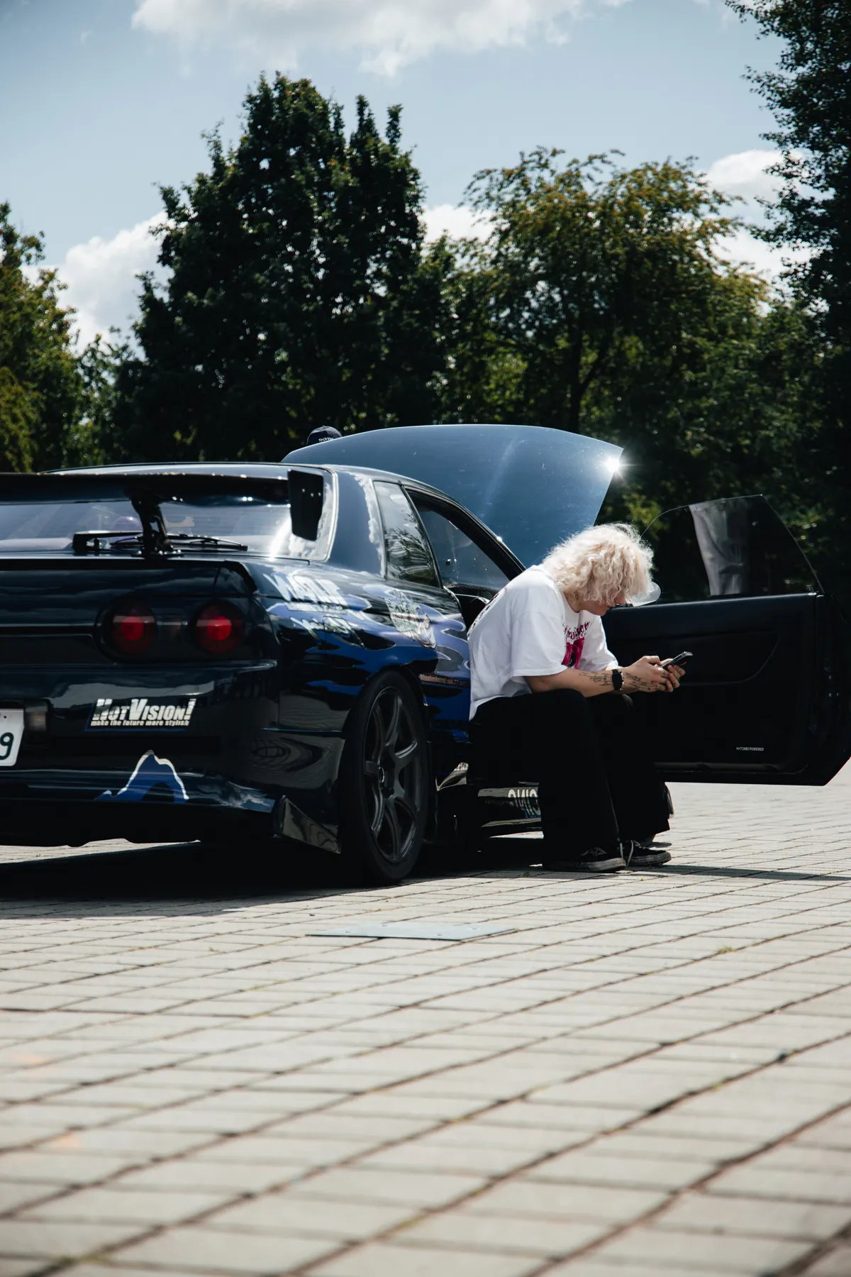 Spectator beside a parked motorsport car